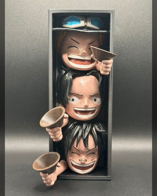 Fermalibro 3D Ace Sabo e Luffy dipinto a mano tra libri su una mensola