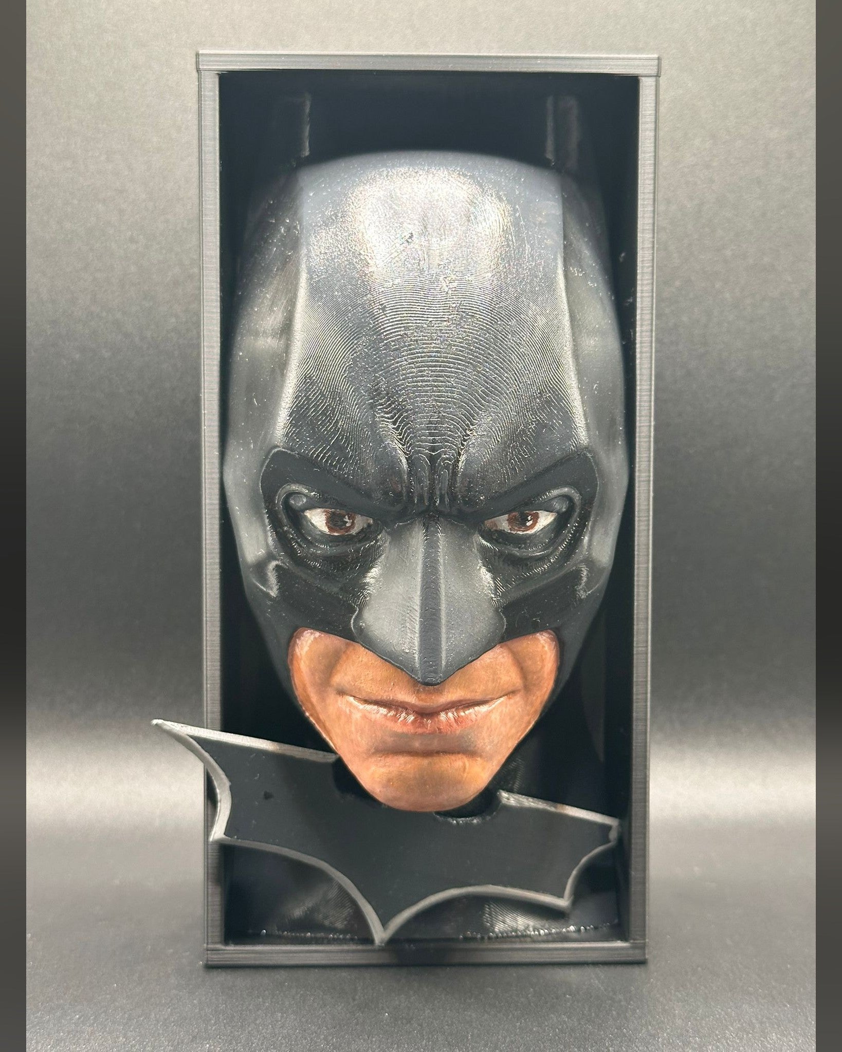 Fermalibro 3D Batman dipinto a mano tra libri su una mensola