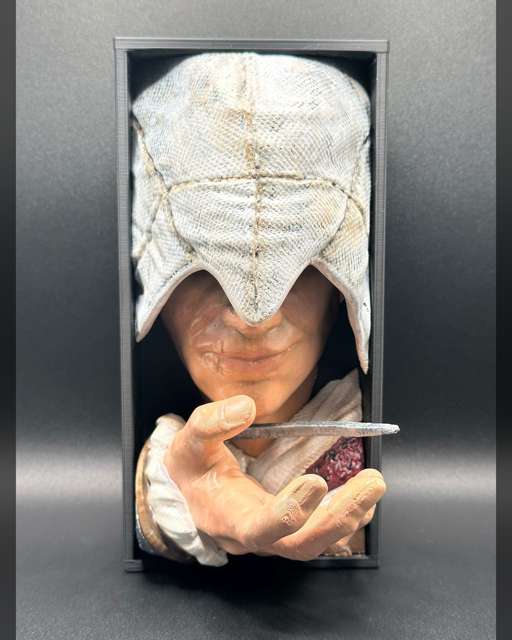 Fermalibro 3D Ezio Auditore dipinto a mano tra libri su una mensola