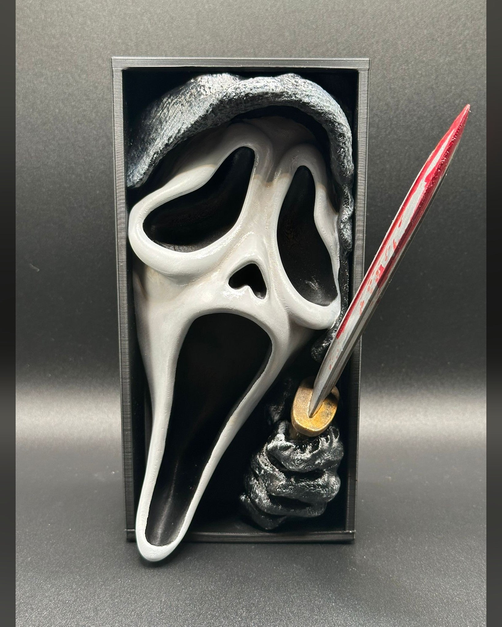 Fermalibro 3D Ghostface dipinto a mano tra libri su una mensola