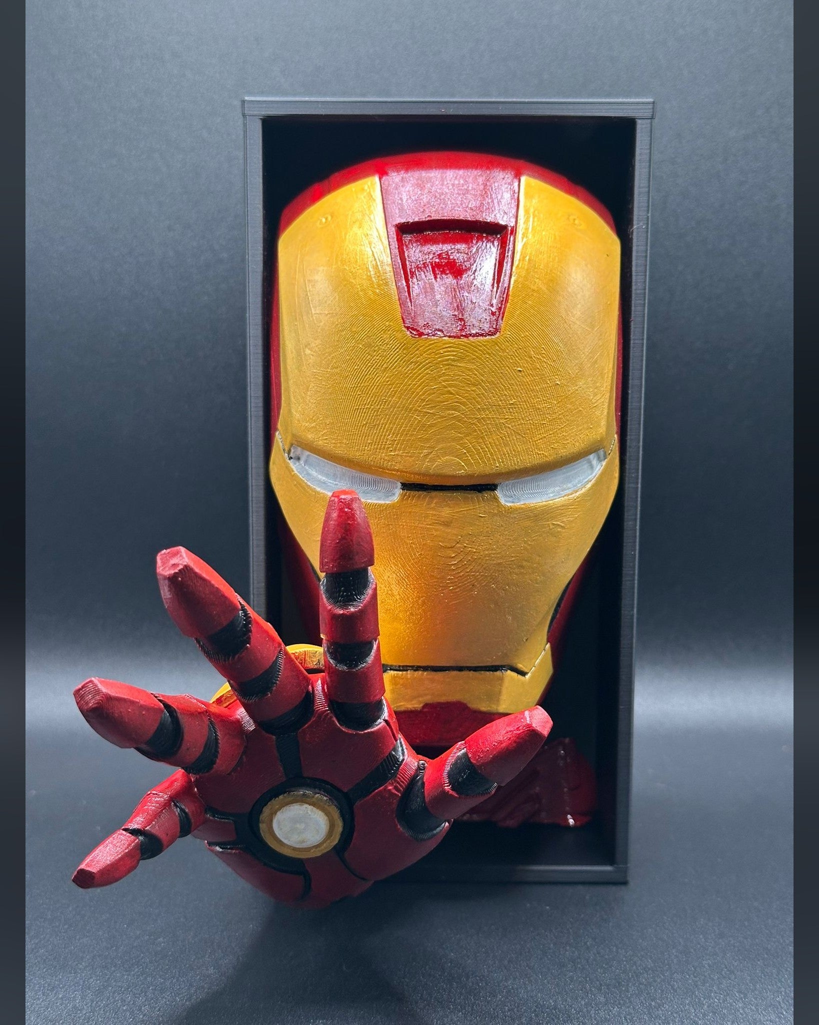 Fermalibro 3D Iron Man dipinto a mano tra libri su una mensola