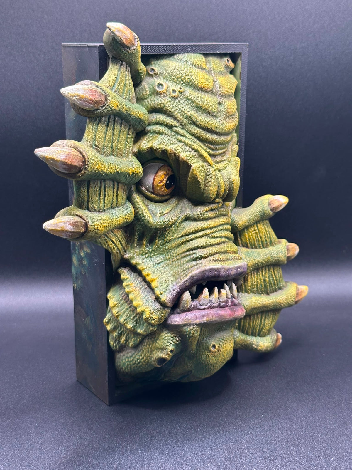 Fermalibro Gill-man di tre quarti, occhi ambrati e dentatura in rilievo