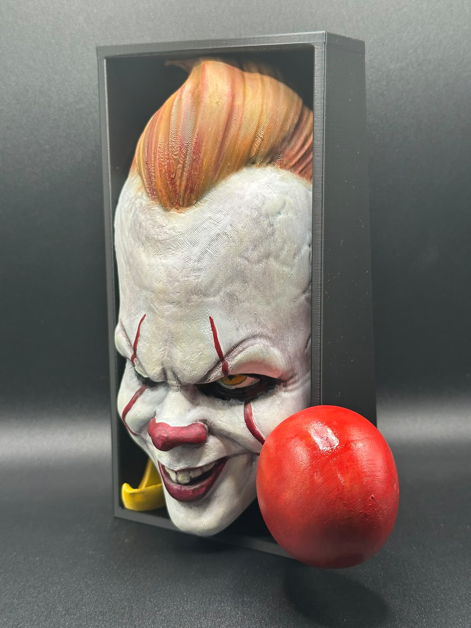 Fermalibro Pennywise visto di lato, dettaglio del ciuffo arancione