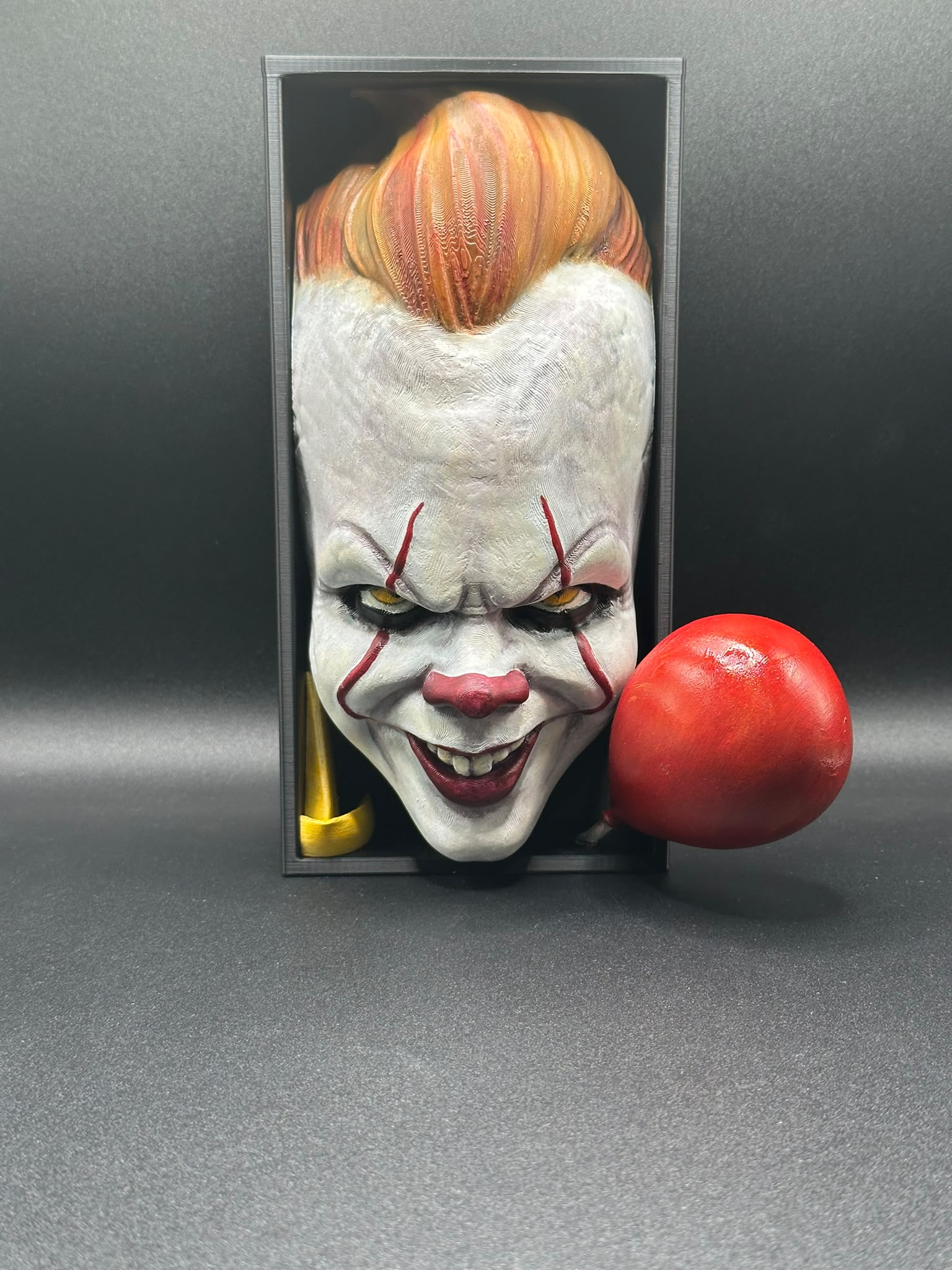 Fermalibro Pennywise con palloncino rosso accanto al blocco portalibri
