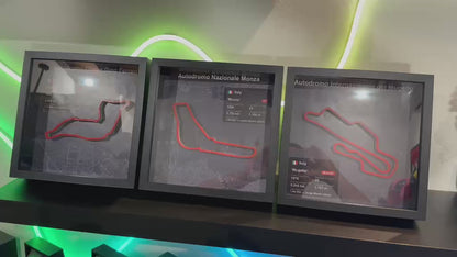 Collezione di quadri circuiti 3D esposti su una mensola con luci al neon